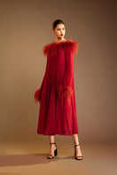 Red Valenciani midi dress with ostrich feather trim and pleated design, showcasing elegant fabric and detailed craftsmanship.
