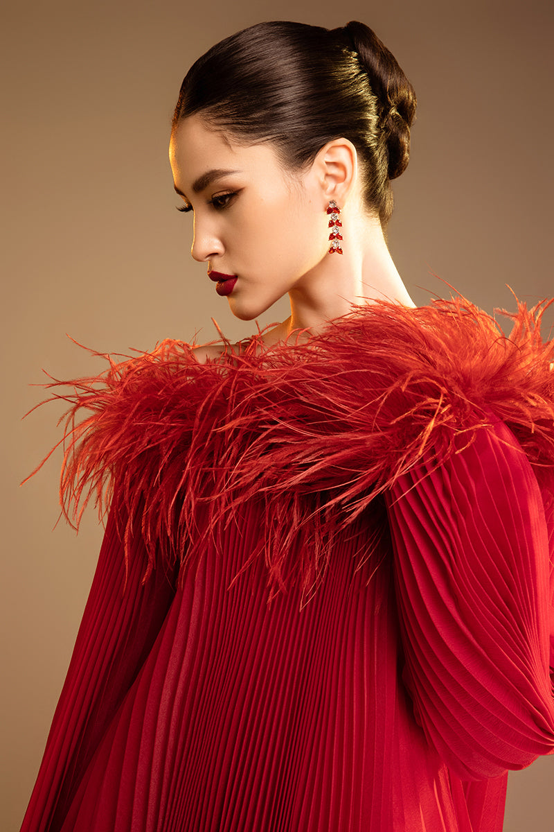 Red Valenciani midi dress with ostrich feather trim and pleated design, showcasing elegant fabric and sophisticated style.