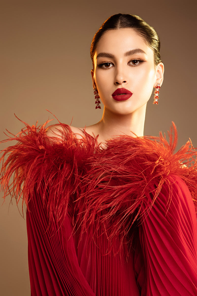 Red Valenciani midi dress with ostrich feather trim and pleated design, showcasing elegant fabric and stylish silhouette.