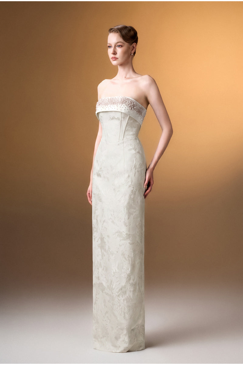 White strapless ballgown in rose design brocade by I.H.F, featuring elegant fabric and a fitted bodice for formal occasions.