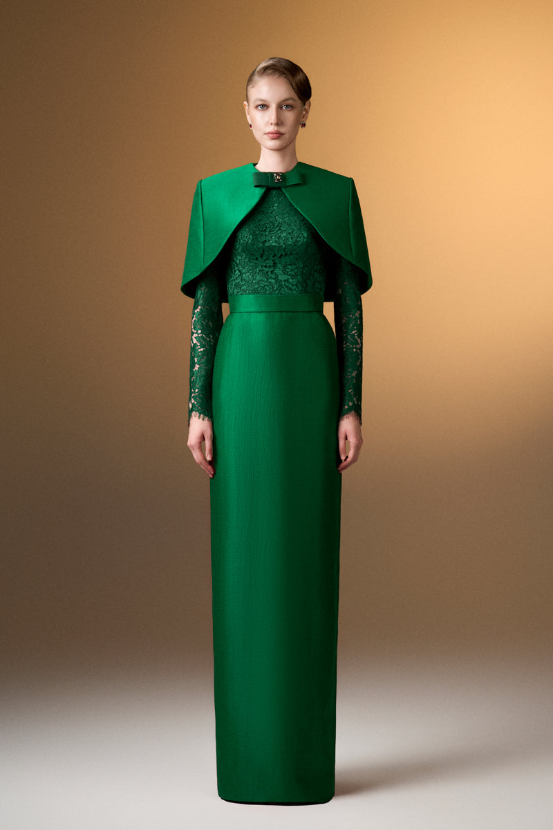 Green round neck column gown with long sleeves and mini cape by I.H.F, shown on a model.