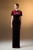 Dark red strapless column gown with a mini velvet cape by I.H.F, featuring a sleek silhouette and elegant design.