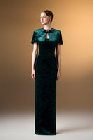 Green strapless column gown with mini cape in grain velvet, by I.H.F, shown on a model with elegant styling.