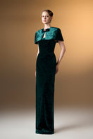 Green strapless column gown with a mini velvet cape from I.H.F, featuring a sleek silhouette and luxurious grain velvet fabric.