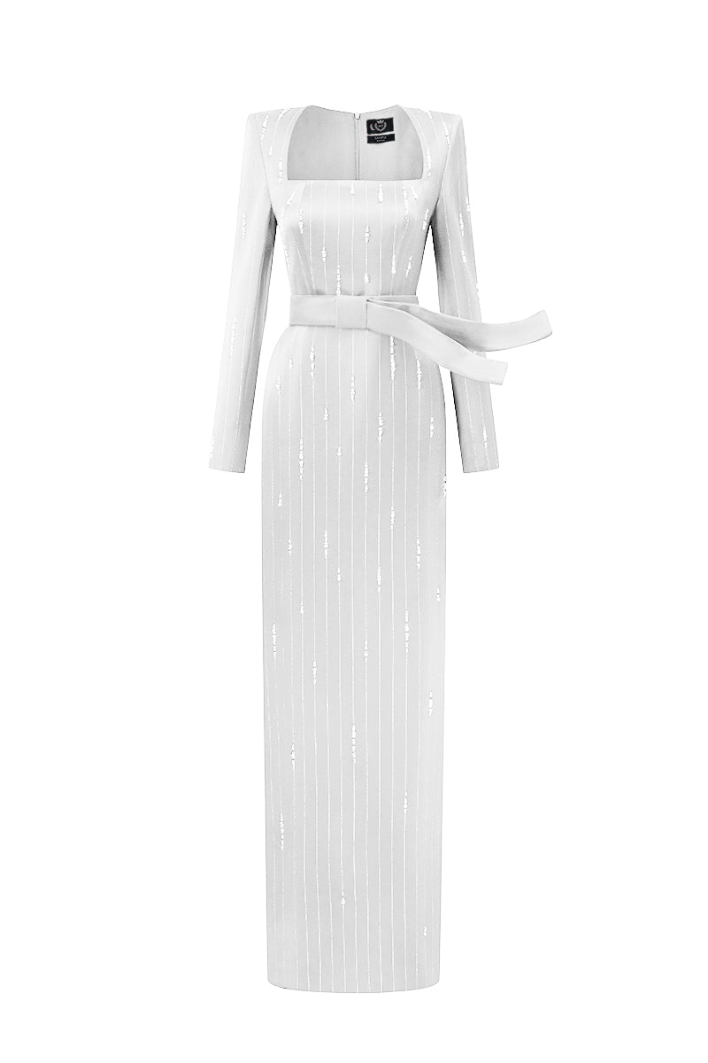 White metallic belted train column gown by I.H.F, featuring a wind-blown silk train and trapeze neckline.