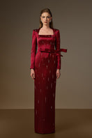 Red metallic belted train column gown by I.H.F featuring a trapeze neck and flowing wind-blown train in striped silk fabric.