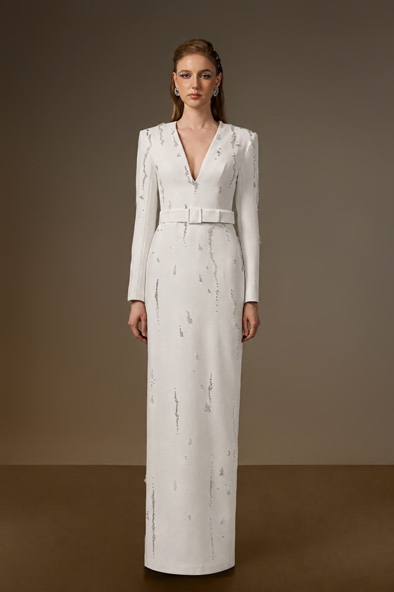 White embellished V-neck column gown by I.H.F with flowing water effect embellishments, elegant crepe fabric, and sleek silhouette.
