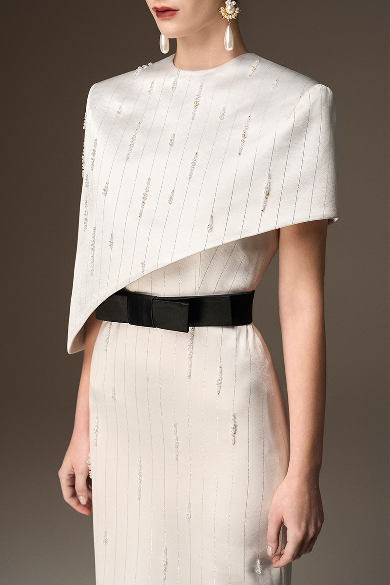 I.H.F Valentina white metallic asymmetrical cape gown with round neck and sleek silhouette in shiny silk fabric.