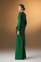 Green crepe trapeze-neck tie dress with diagonal hip drape, stylish gown by I.H.F. displayed on a hanger.