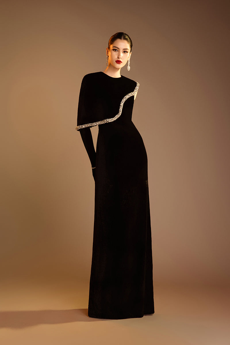 Black Valenciani gown with gem-embellished trim, elegant cape design, perfect for formal occasions.