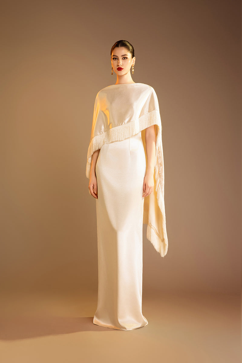 Cream Valenciani column gown with fringed trim cape, elegant evening dress featuring flowing fabric and stylish design.