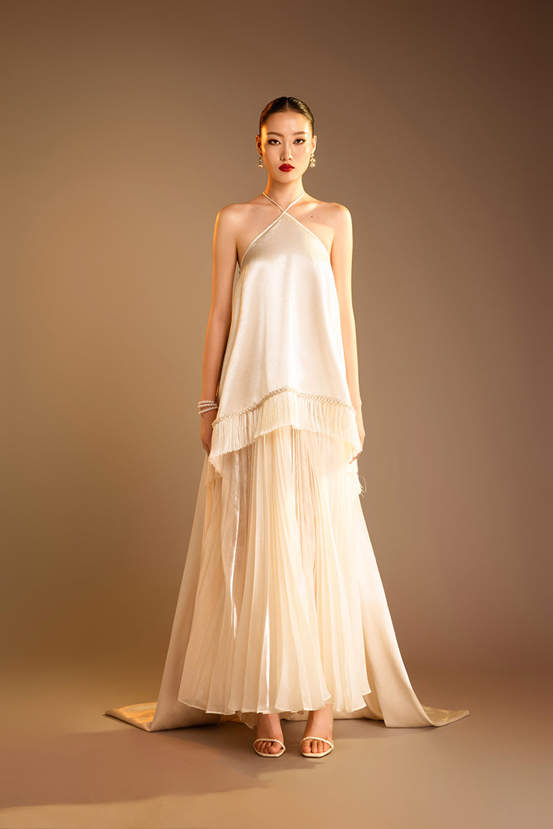 Cream Valenciani halterneck pleated maxi dress, midi length with flowing fabric, perfect for elegant occasions.