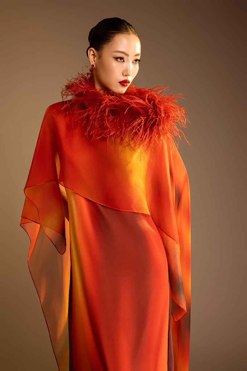 Valenciani printed orange gown with a detachable ostrich feather trim cape, elegant evening dress with bold style.