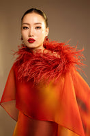 Orange printed gown with a detachable ostrich feather trim cape by Valenciani, elegant evening wear with intricate detailing.