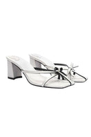 White Christin Wu Adrianna sandals with open toes and ankle straps, shown on a neutral background.