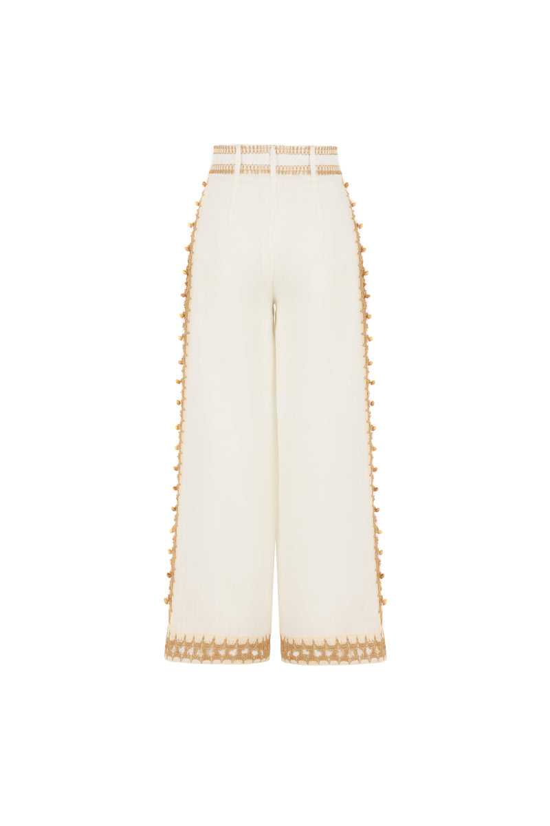 A pair of white natural Dune pants by AISA displayed on a hanger, showcasing their relaxed fit and lightweight fabric.