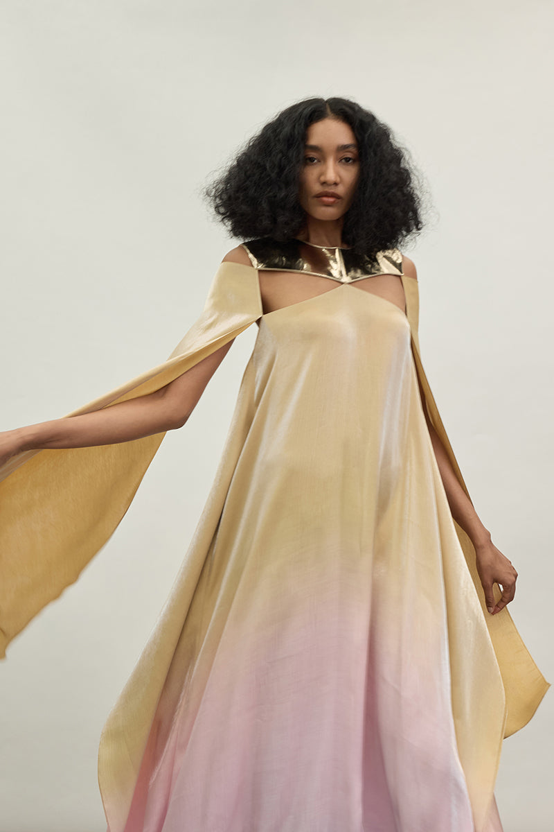 Elegant gold spectrum gown by AKHL featuring flowing fabric and intricate detailing, perfect for formal occasions.
