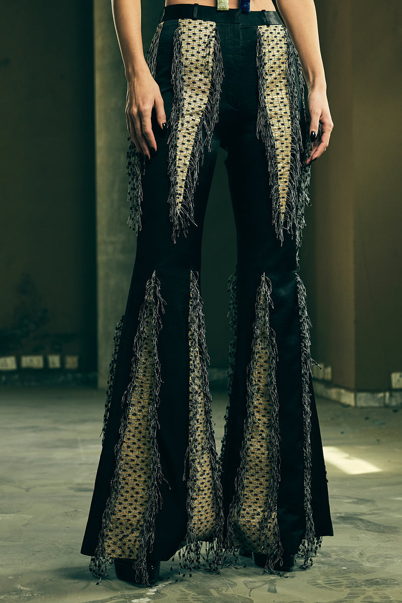 Handwoven panelled boot-cut trousers by AKHL, featuring textured fabric and tailored fit, shown on a model.