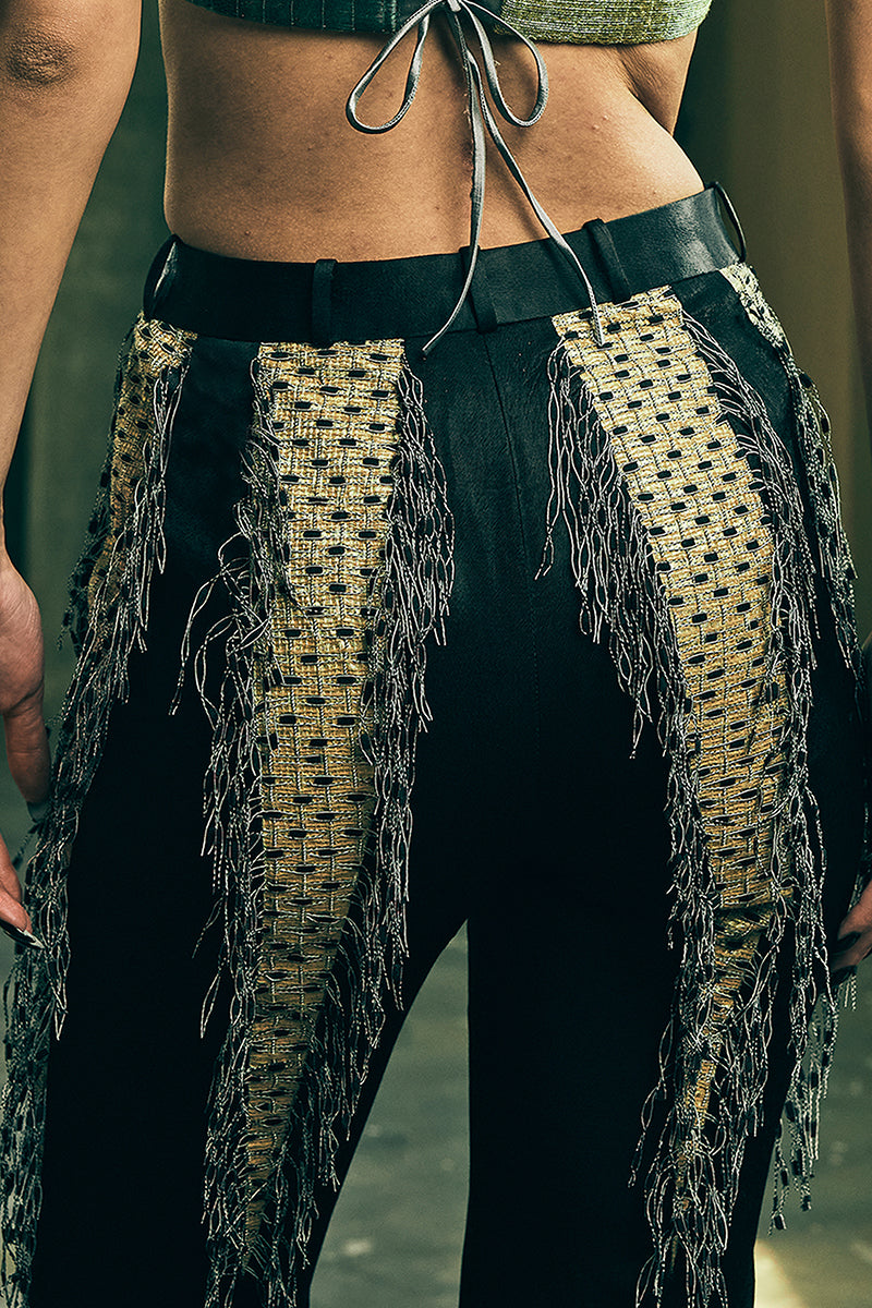 Handwoven panelled boot-cut trousers by AKHL, featuring intricate woven fabric and tailored fit, shown on a model.