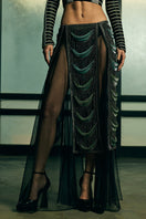 Sheer panelled fringe maxi skirt by AKHL, featuring flowing fabric and decorative fringe details on a stylish design.