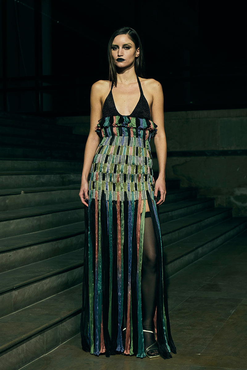 Black AKHL dimensional column maxi skirt with structured design and flowy fabric, styled for elegant wear.
