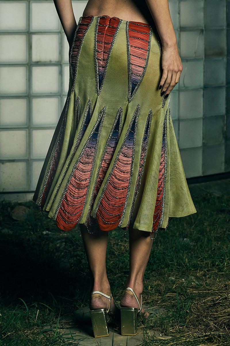 Low-waist panelled midi skirt by AKHL featuring a structured design and sleek silhouette, displayed on a neutral background.