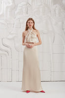 Elegant champagne halter neck evening maxi dress by UNDRESS, featuring a flowing design and sophisticated style for formal occasions.
