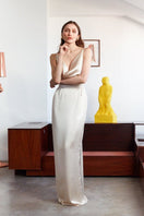 Undress beige satin backless maxi dress displayed on a model, featuring elegant flowy fabric and a floor-length design.