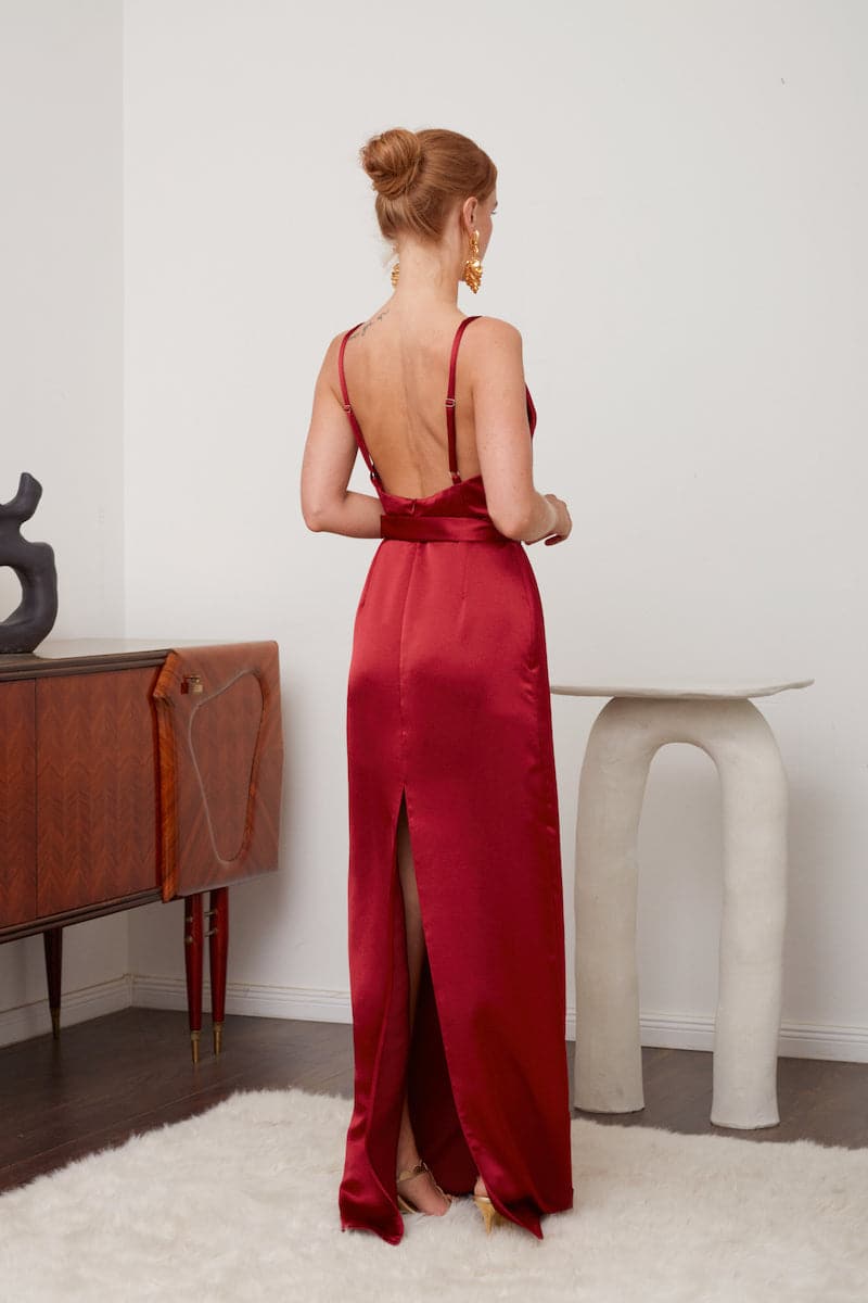 Deep red backless maxi dress by UNDRESS, flowing evening gown with elegant design and sleeveless style, suitable for formal occasions.