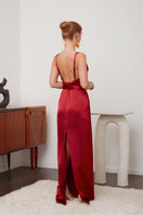 Deep red backless gown by UNDRESS with flowing fabric and elegant design, perfect for evening occasions.