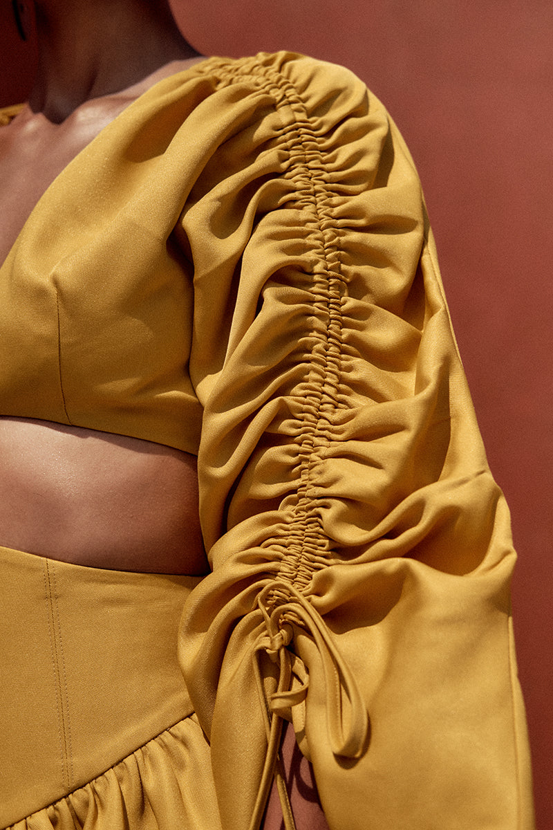 Bright gold INDA crop top by Andrea Iyamah, featuring a sleek, stylish design perfect for modern fashion looks.