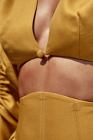 Bright gold INDA crop top by Andrea Iyamah, featuring a stylish and fitted design, shown on a model in a fashion lookbook.