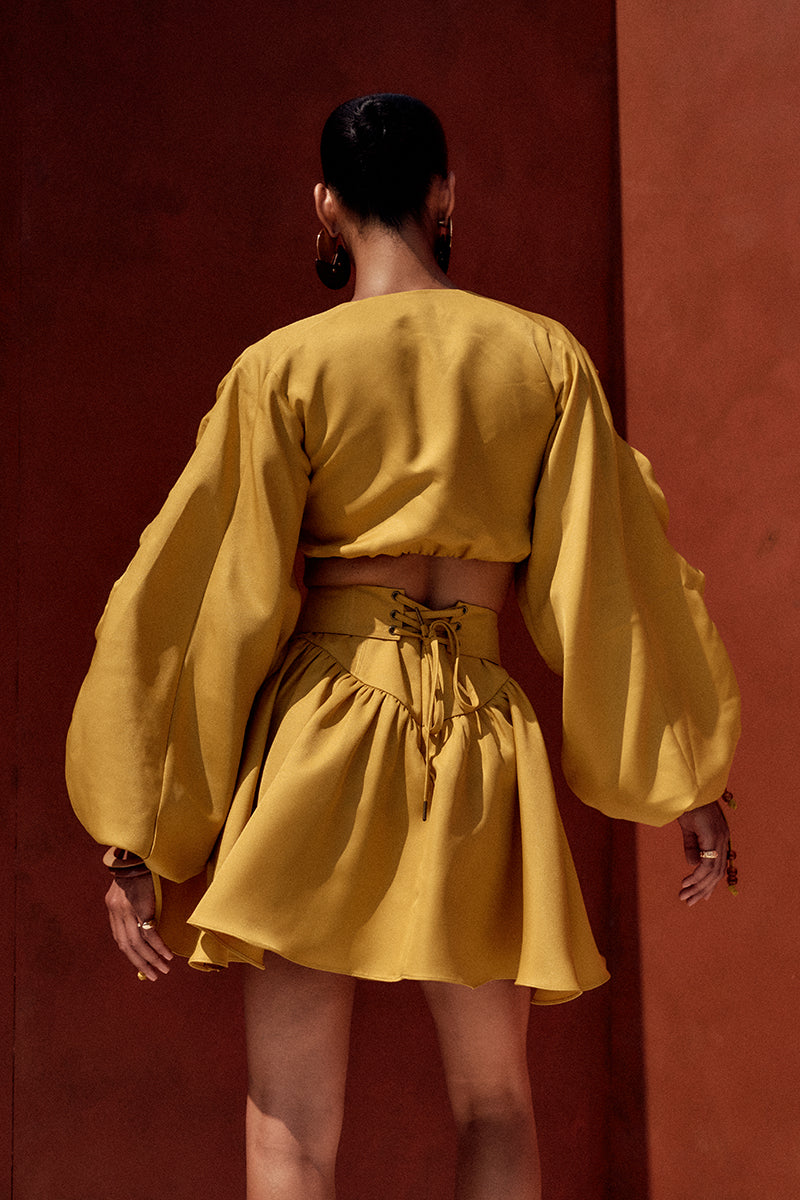 Bright gold INDA crop top from Andrea Iyamah featuring a fitted design and stylish sleeveless cut.