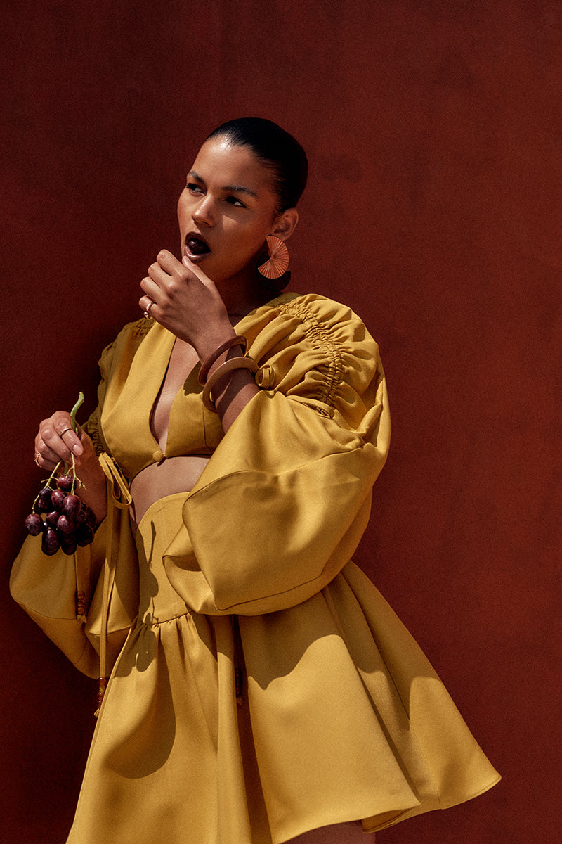 Andrea Iyamah bright gold mini skirt from the INDA collection, stylishly designed with a sleek fit and vibrant color.