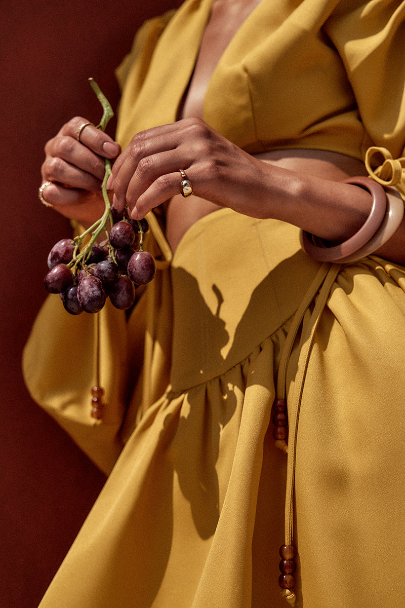 Andrea Iyamah bright gold crop top from the INDA collection, featuring a stylish sleeveless design and fitted silhouette.
