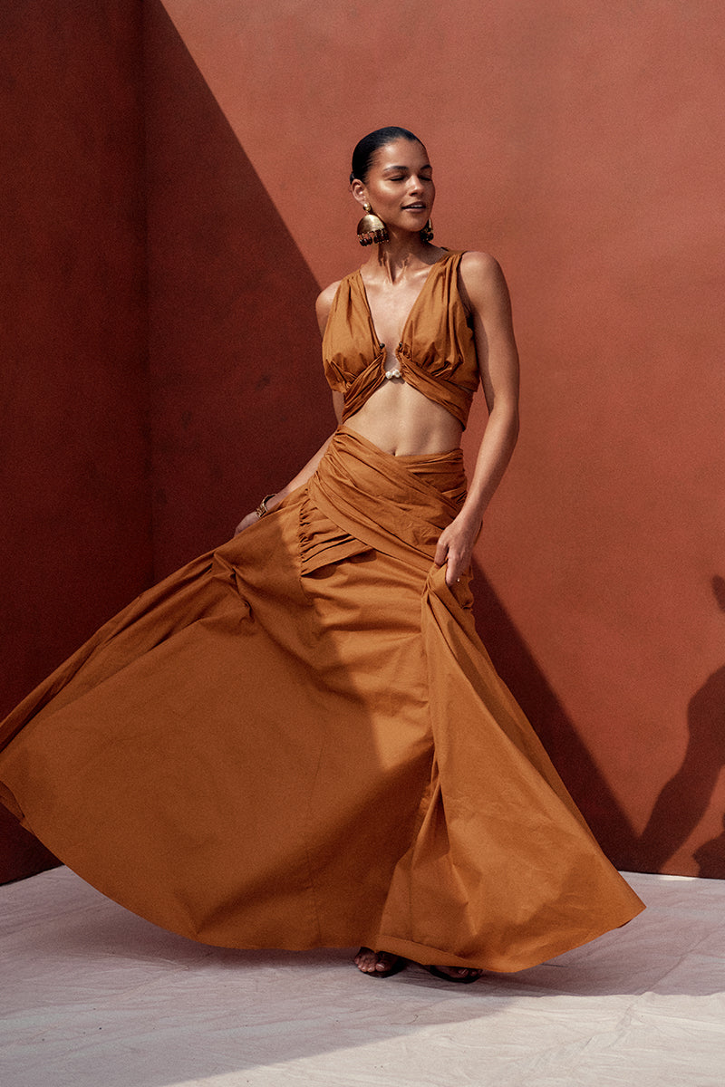Andrea Iyamah GIA maxi skirt in burnt orange, flowing fabric with a high waist and elegant design, perfect for stylish summer wear.