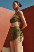 Olive green Andrea Iyamah Makena fringe bikini top with layered fringe details and adjustable straps on a model.