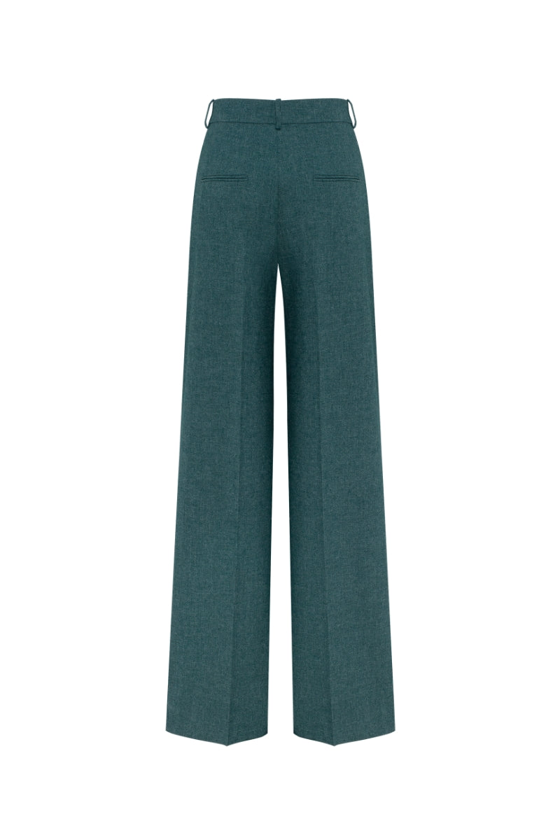 Podyh Seccesia pants in rich teal fabric with a relaxed fit, shown on a model standing against a neutral background.