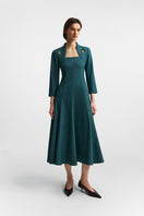 Podyh Edicule teal midi dress displayed on a hanger, showcasing its elegant design and rich teal color.