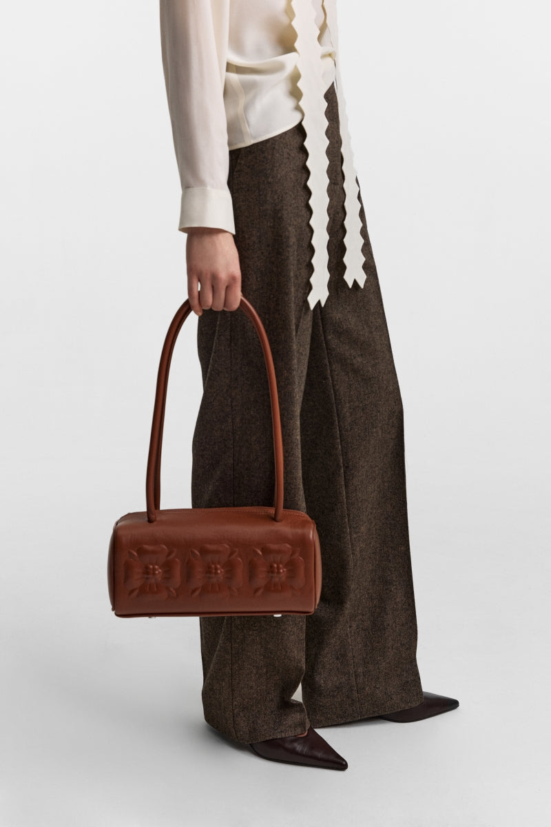 PODYH brown top handle bag with bas relief design, featuring a stylish and elegant accessory for everyday use.