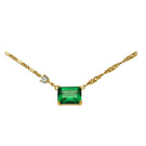 Emerald green and gold necklace by Amelia Scott featuring intricate design, displayed on a neutral background.