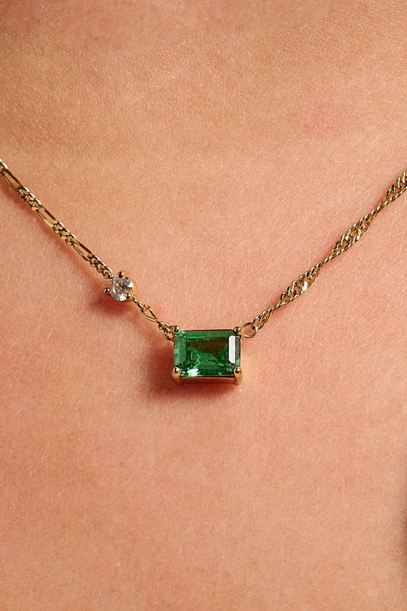 Emerald green and gold necklace by Amelia Scott featuring a delicate chain and elegant pendant on a white background.