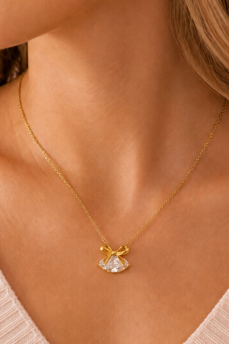 Gold Amelia Scott bow necklace with clear CZ stones, elegant jewelry piece featuring a stylish bow design.
