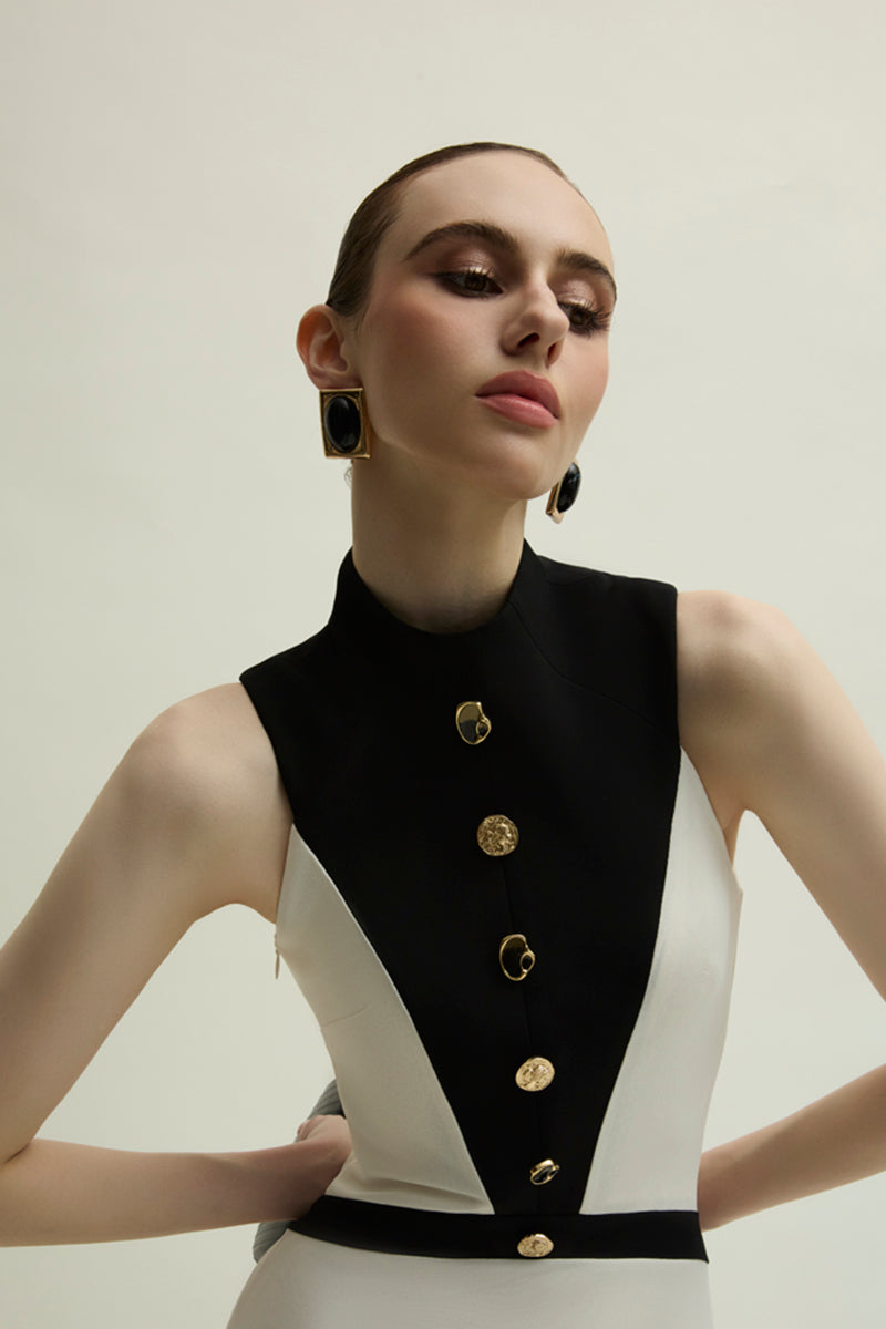 Jenny K Tran Aster ivory and black gown featuring elegant draping and a fitted silhouette, styled with a high neckline and long sleeves.
