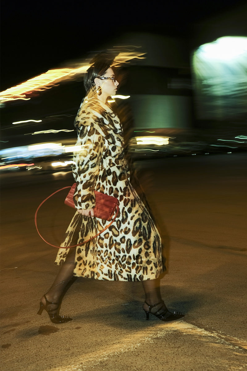 Blikvanger leopard faux fur coat displayed on a hanger, showcasing its animal print and plush texture.