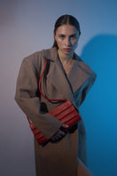 Long hazelnut beige coat by Blikvanger, featuring a tailored design and classic collar, displayed on a hanger against a neutral background.