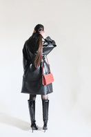 Black faux leather high-neck trench coat by Blikvanger with a sleek, stylish design and tailored fit.