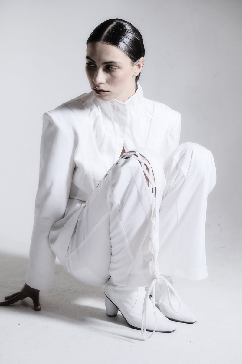 White high-neck pleated blazer by Blikvanger featuring structured design and elegant pleats, perfect for stylish formal wear.