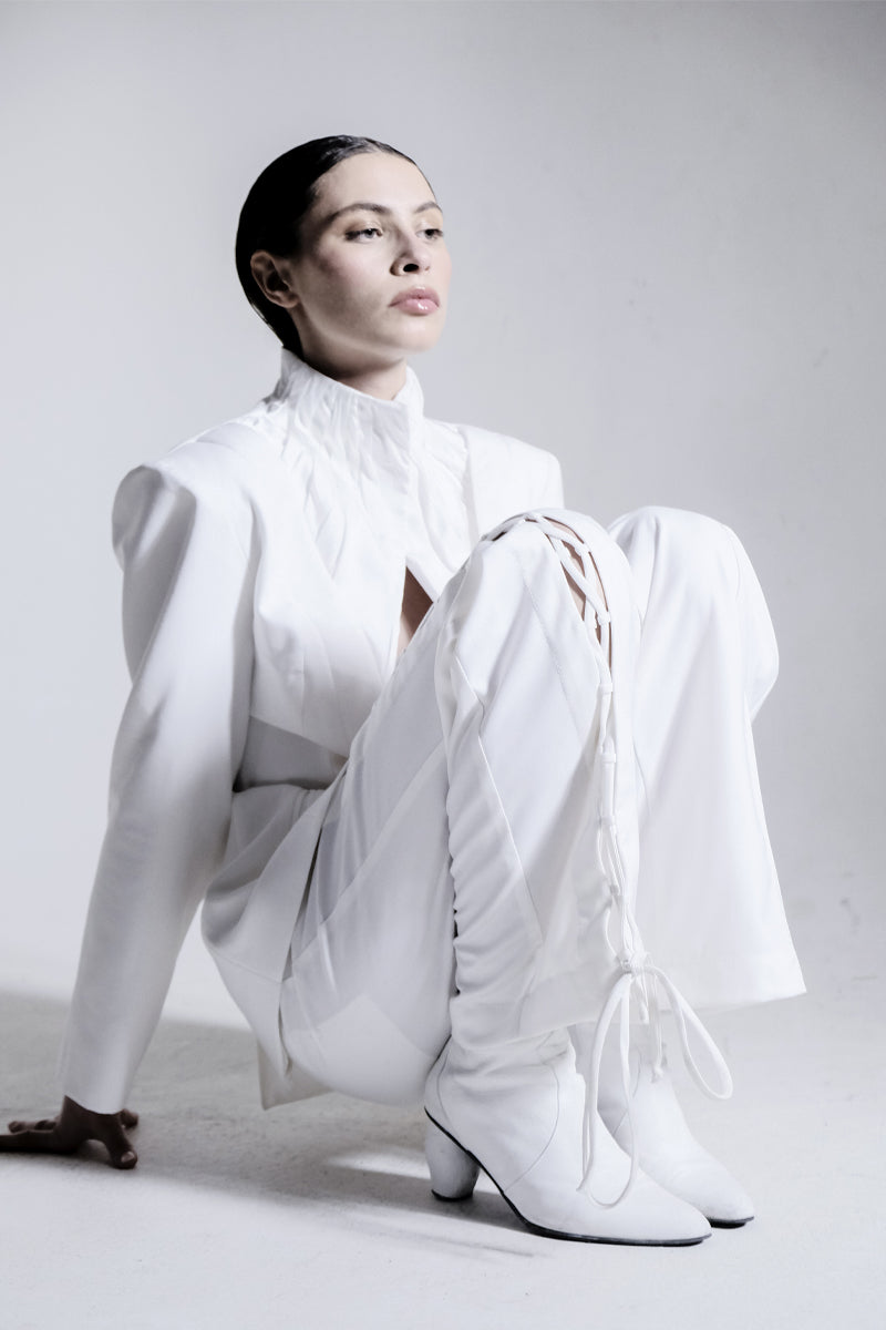 White high-neck pleated blazer by Blikvanger featuring structured design and tailored fit, shown on a neutral background.