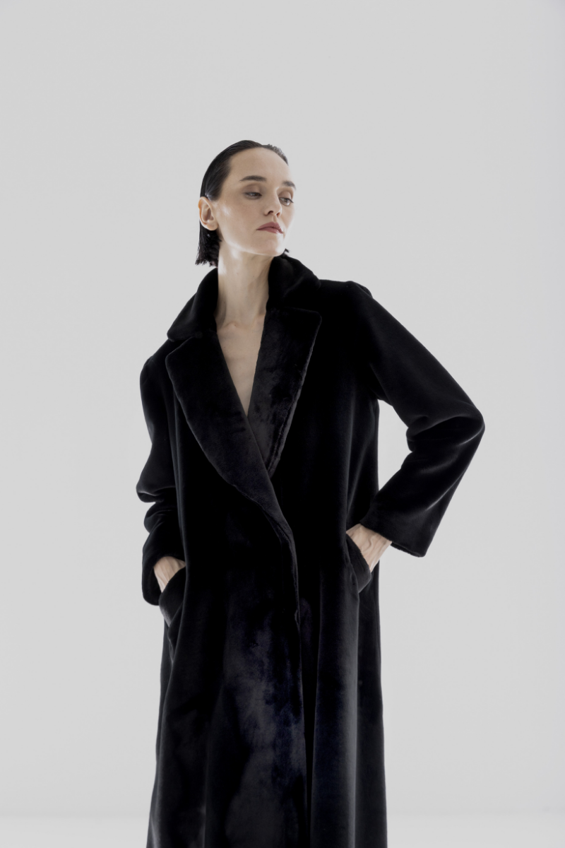 Black vegan fur maxi coat by Lili Blanc, showcased on a model with a stylish, luxurious look.